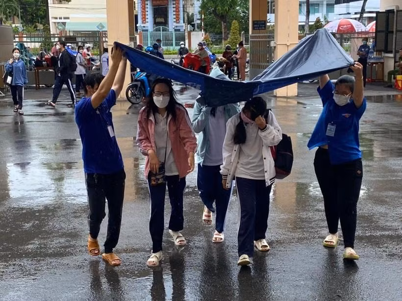 Thí sinh Tiền Giang đến điểm thi trong cơn mưa.