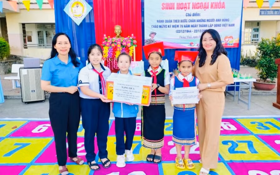 Trường Tiểu học Hoàng Văn Thụ (TP Kon Tum) tặng quà, Bảo hiểm y tế cho học sinh trường khó khăn nhân dịp Tết đến Xuân về. Ảnh: Dung Nguyễn