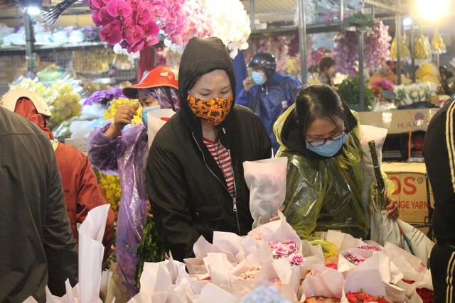 Nhiều khách hàng bất chấp thời tiết mưa lạnh của Hà Nội đã có mặt từ sớm tại chợ hoa Quảng An. Ảnh: dantri.com.vn.