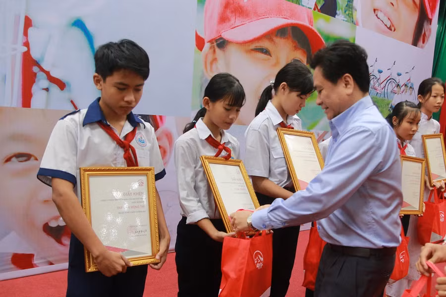 Ông Trần Văn Dũng - Phó Chủ tịch UBND tỉnh Tiền Giang trao quà cho các em HS.