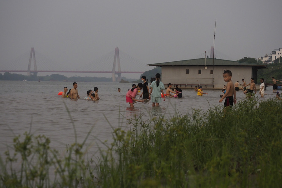 Nhiều học sinh bơi lội dưới sông Hồng chiều 7/5 tiềm ẩn nhiều nguy cơ đuối nước.