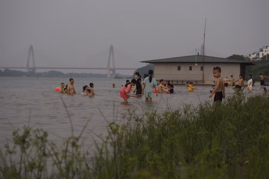 Nhiều học sinh bơi lội dưới sông Hồng chiều 7/5 tiềm ẩn nhiều nguy cơ đuối nước.