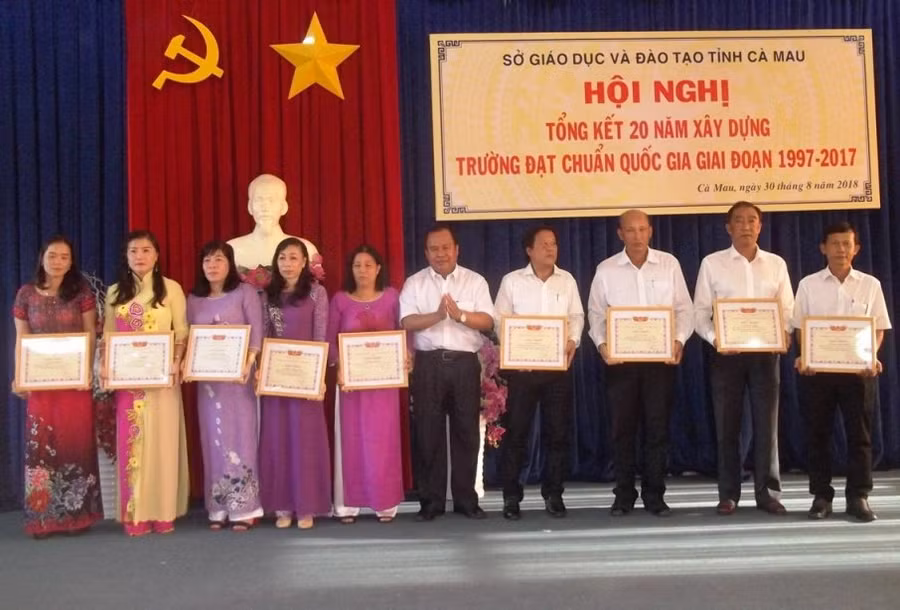Giám đốc Sở GD&ĐT Cà Mau Nguyễn Minh Luân trao giấy khen cho các tập thể và cá nhân hoàn thành tốt trong công tác xây dựng trường chuẩn QG
