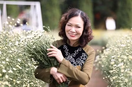 Cô giáo Lã Thị Thu Hoàn, giáo viên trường Tiểu Học Trung Lương (Hà Nam) bên những bông cúc Họa Mi tinh khôi (Ảnh Vũ Kiên)