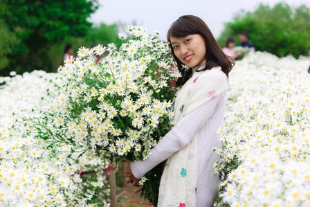 Cô giáo trẻ Nguyễn Thu Thủy, giáo viên âm nhạc trường THCS Phan Chu Trinh (Hà Nội) say sưa tạo dáng cùng cúc Họa Mi (Ảnh Thế Đại)