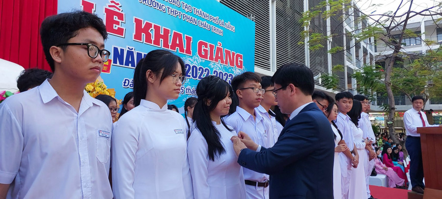 Thầy Hiệu trưởng Trường THPT Phan Châu Trinh (Đà Nẵng) gắn bảng tên trong lễ đón học sinh lớp 10 vào trường dịp khai giảng năm học mới.