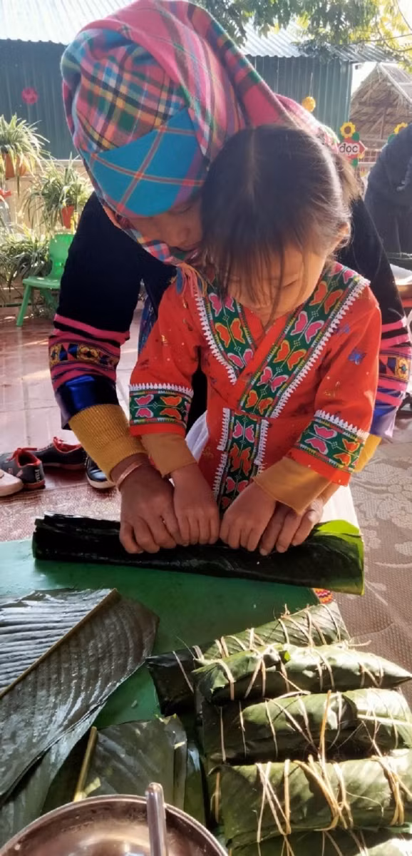 Phụ huynh và học sinh Trường Mầm non Si Pa Phìn (huyện Nậm Pồ) cùng tham gia trải nghiệm gói bánh chưng Tết.