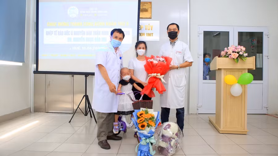 GS. TS Phạm Như Hiệp, Giám đốc Bệnh viện Trung ương Huế tặng hoa chúc mừng bệnh nhi trong ngày ra viện.