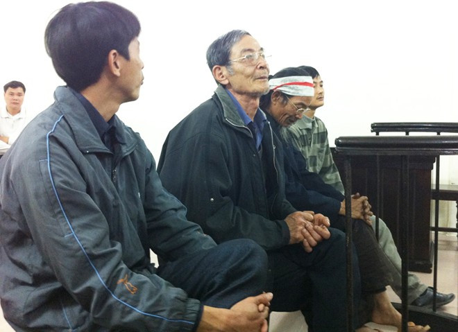 Bị cáo Hòa (đeo khăn). Bị trói bằng dây xích sắt vì quay phim, chụp ảnh