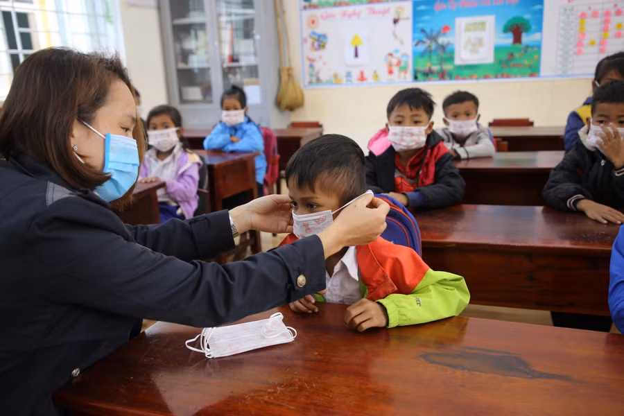 Giáo viên Trường TH&amp;THCS A Xing hướng dẫn HS đeo khẩu trang phòng dịch Covid-19