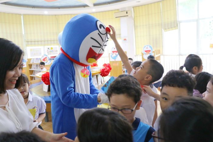 Em nhỏ nào cũng thích thú khi được vây quanh và chạm vào chú mèo máy mình đã yêu thích trong truyện tranh trong lễ kỷ niệm 10 năm thành lập thư viện Fujiko F. Fujio. 
