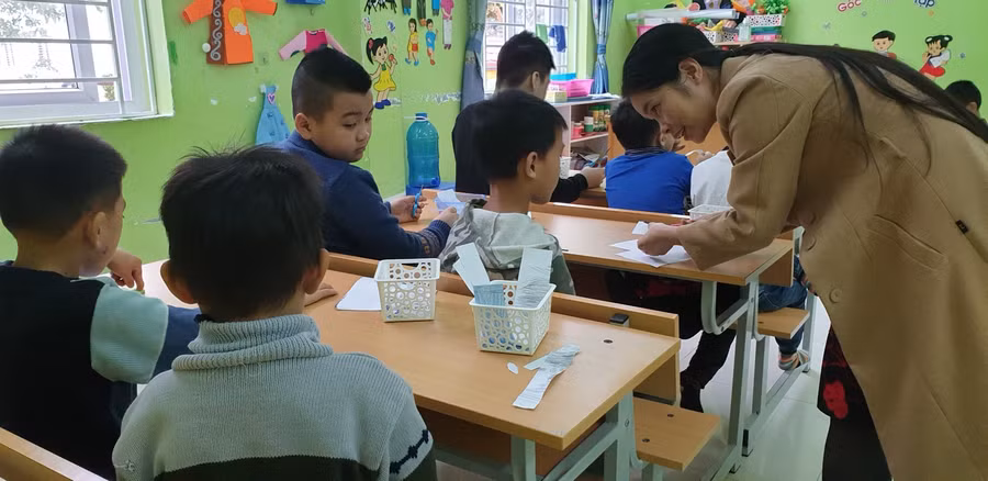 Lớp học theo nhóm học sinh được làm thủ công với giấy để rèn luyện kỹ năng tập trung.