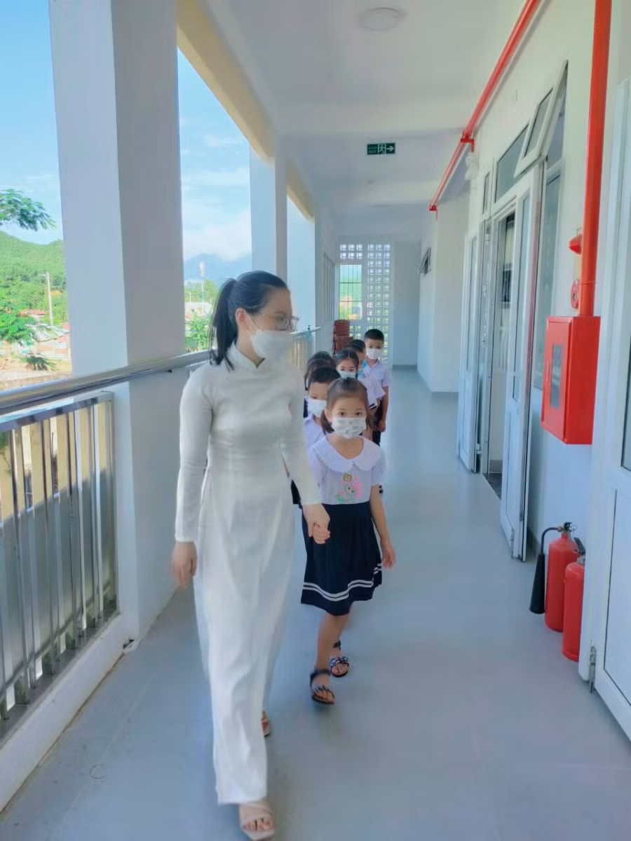 Cô giáo dẫn học sinh về lớp