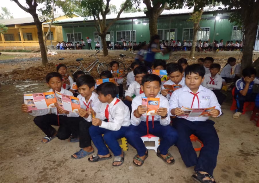 Các em HS xem tờ bướm tuyên truyền phòng chống tác hại thuốc lá. Ảnh: CTV.