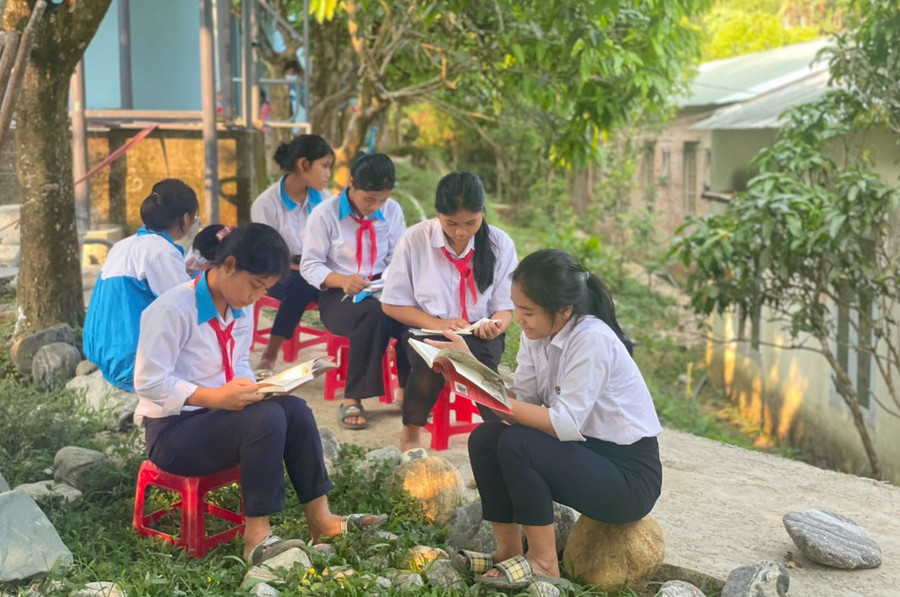 Học sinh Trường PTDTBT Tiểu học - THCS Trà Nam đọc sách ở thư viện di động đặt tại sân trường. Ảnh: TG