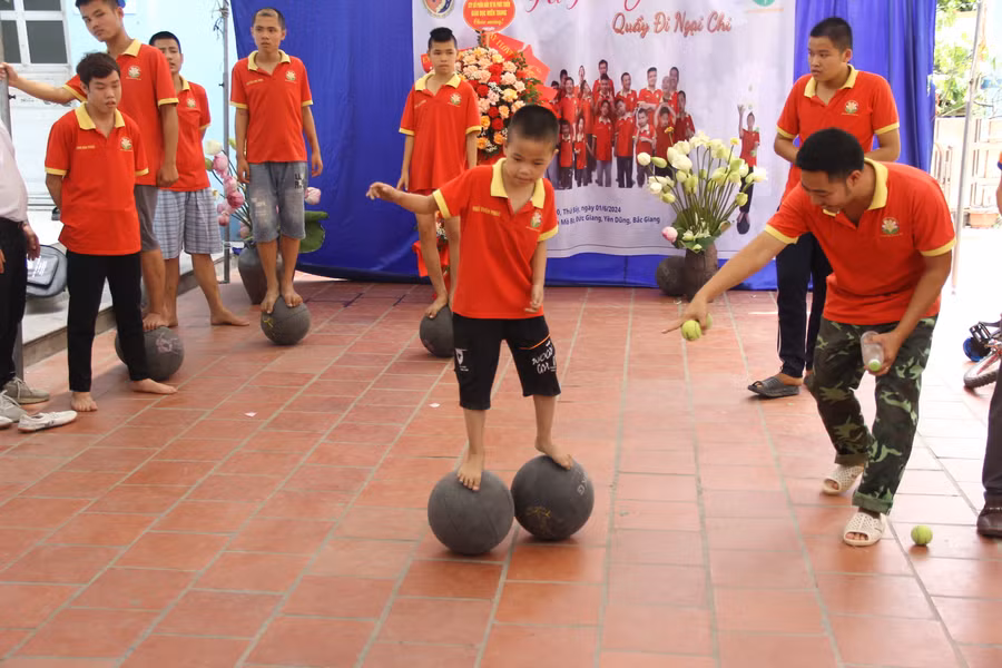 Thầy Vũ Văn Chức hướng dẫn trẻ tự kỷ di chuyển bằng bóng.