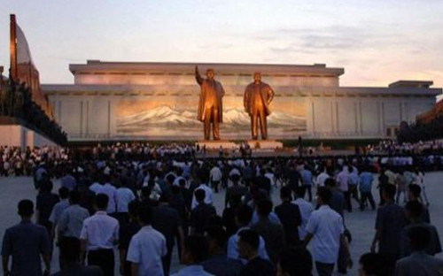 Người dân Triều Tiên đặt hoa tưởng niệm trước bức tượng đồng của Chủ tịch Kim Nhật Thành (Kim Il Sung) và nhà lãnh đạo thứ hai Kim Jong-il (ảnh: DM)