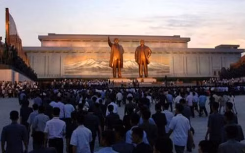 Người dân Triều Tiên đặt hoa tưởng niệm trước bức tượng đồng của Chủ tịch Kim Nhật Thành (Kim Il Sung) và nhà lãnh đạo thứ hai Kim Jong-il (ảnh: DM)