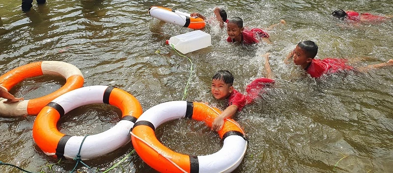 Trẻ được thực hành kỹ năng cứu đuối bằng cách ném phao, can nhựa cho người gặp nạn.