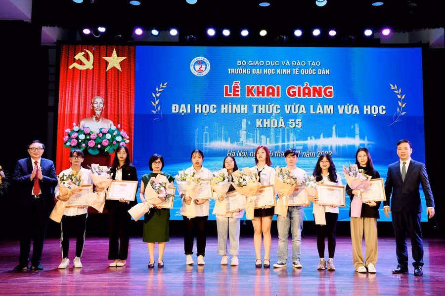 PGS.TS Bùi Huy Nhượng - Phó Hiệu trưởng, PGS.TS Phạm Quang - Trưởng khoa ĐH Tại chức trao giấy khen và tặng hoa cho các tân sinh viên. 