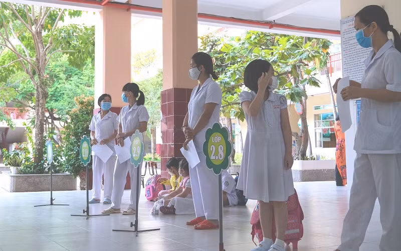 Các cô Trường TH Ngô Quyền, quận Ninh Kiều (TP Cần Thơ) đón học sinh từ cổng, tránh tập trung đông người khu vực trường. Ảnh: TG