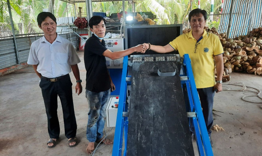 Nhóm nghiên cứu Trường ĐH Trà Vinh bàn giao máy tách vỏ dừa cho doanh nghiệp chế biến dừa tỉnh Bến Tre. Ảnh: NTCC