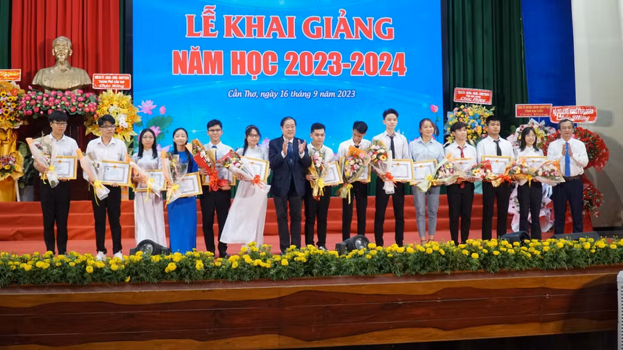 GS.TS Nguyễn Thanh Phương - Bí thư Đảng ủy, Chủ tịch Hội đồng Trường (bìa phải) và GS.TS Hà Thanh Toàn, Hiệu trưởng khen thưởng 13 tân SV đạt điểm cao vào trường.