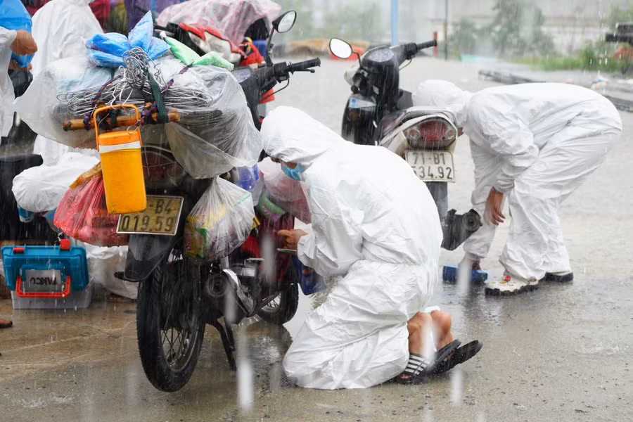 Đội mưa kiểm tra, sửa xe trong khi người dân tranh thủ nghỉ ngơi trước khi qua hầm Hải Vân.