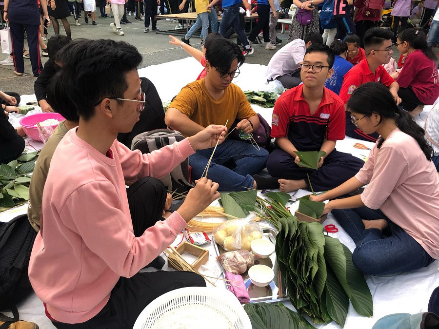 Học sinh thi gói bánh chưng với sự hướng dẫn của phụ huynh, giáo viên