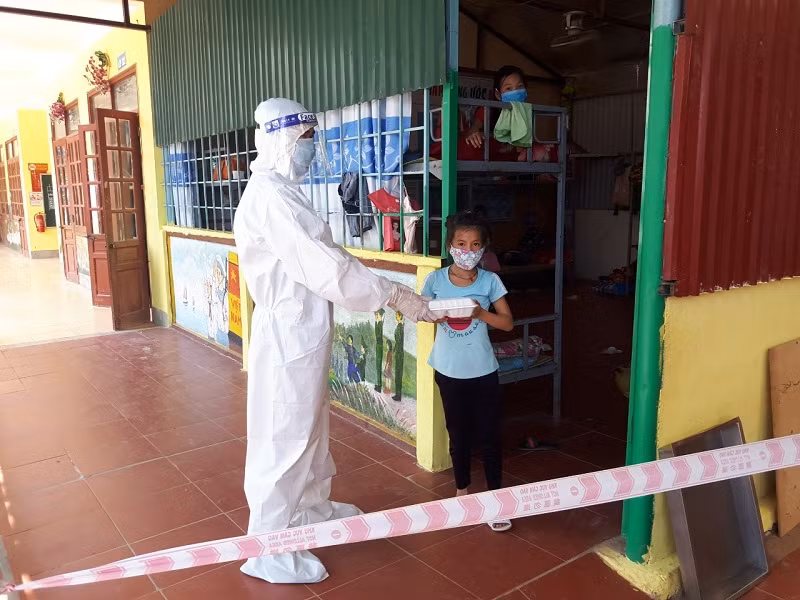 Cán bộ y tế hỗ trợ đưa thức ăn đến cho học sinh tiểu học ở các điểm cách ly tại xã Si Pa Phìn, huyện Nậm Pồ.