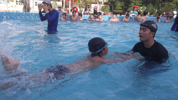 Giáo viên dạy bơi cho học sinh