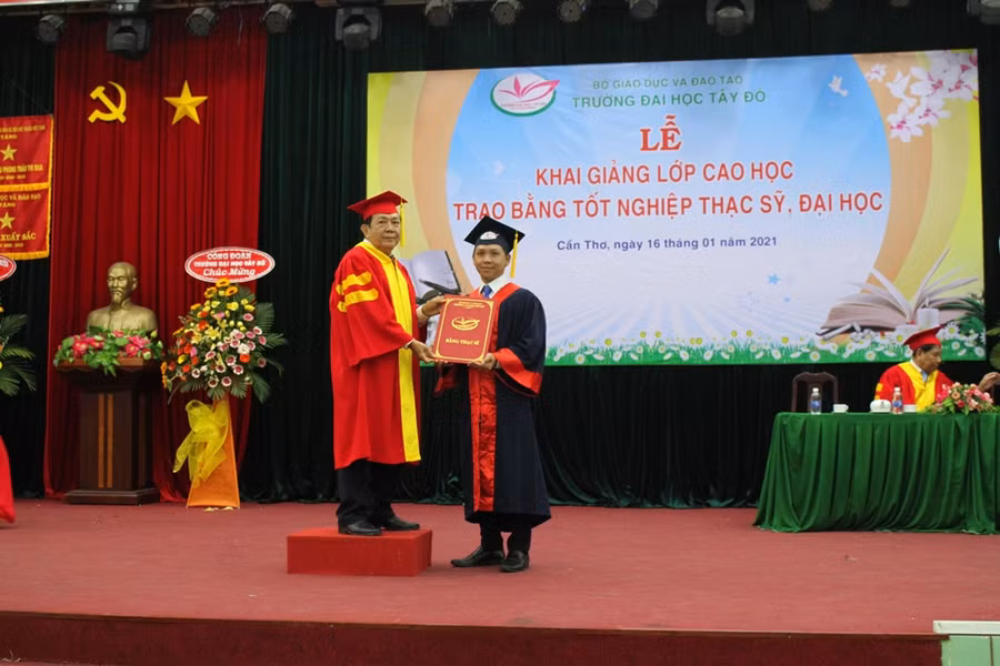 Lãnh đạo trường trao bằng thạc sĩ cho học viên.