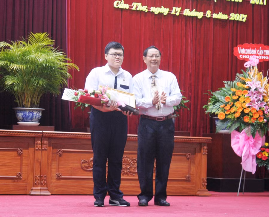 Ông Lê Văn Tâm - Phó Chủ tịch Thường trực UBND TP Cần Thơ tặng bằng khen cho em Nguyễn Diệp Xuân Quang - đạt Huy chương bạc Kỳ thi Olympic Tin học Châu Á Thái Bình Dương