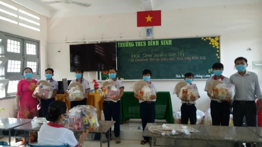 Cô Trang (trái) trao quà cho các em HS trong chương trình “Chia Tết”.