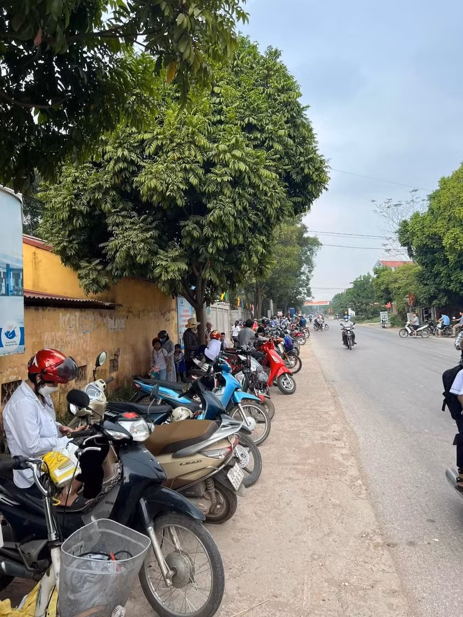 Phụ huynh học sinh trường Tiểu học Kha Sơn xếp xe máy ngay ngắn trước giờ tan trường đợi đón con cháu.