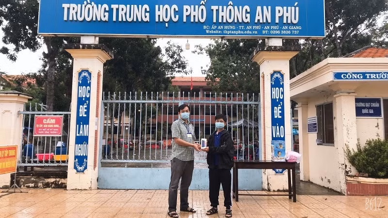 Trao điện thoại thông minh cho học sinh khó khăn để học trực tuyến của Trường THPT An Phú. Ảnh: NTCC