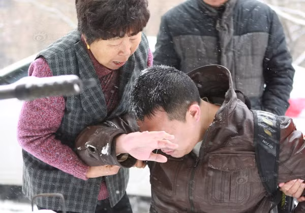 Nhiều người đến khuyên giải chàng trai. Mô tả ảnh.