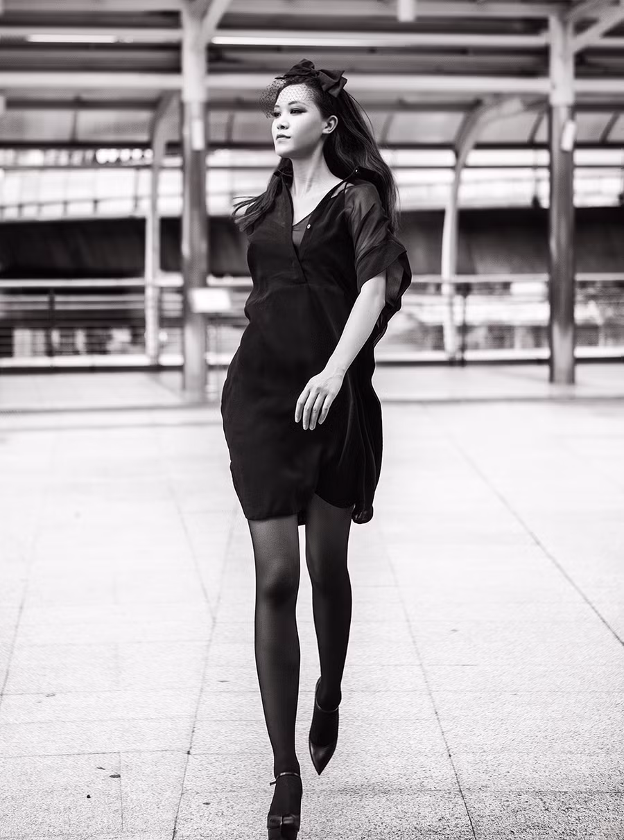 Lớp áo voan mỏng phối kèm váy ôm tối màu là chọn lựa phù hợp cho vóc dáng cân đối của hoa hậu.