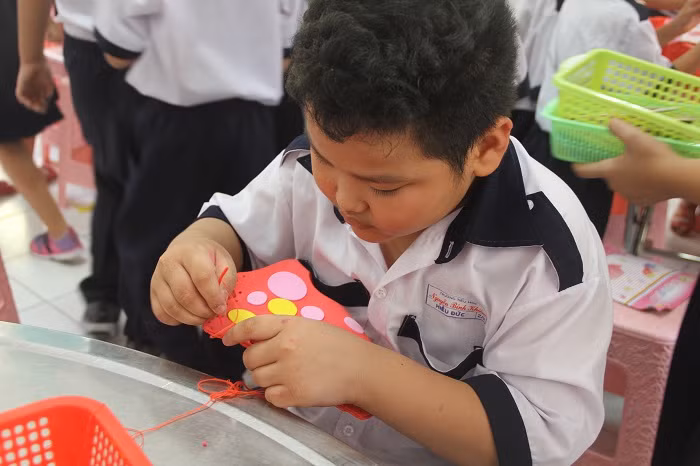 Các bạn nam cũng rất chăm chú để hoàn thành chiếc túi xách