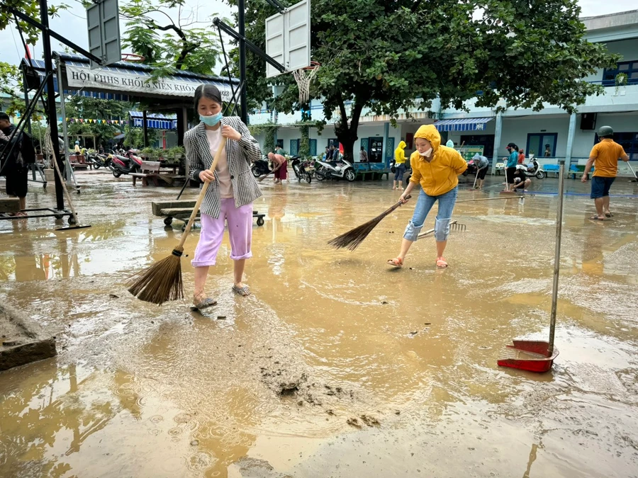 Trường Tiểu học Hồng Quang huy động giáo viên và phụ huynh hỗ trợ dọn vệ sinh sân trường sau 2 ngày bị ngập nước. 