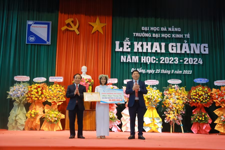 Đại diện Ban Giám đốc ĐH Đà Nẵng và Trường ĐH Kinh tế khen thưởng thủ khoa đầu vào của trường năm 2023 - 2024.