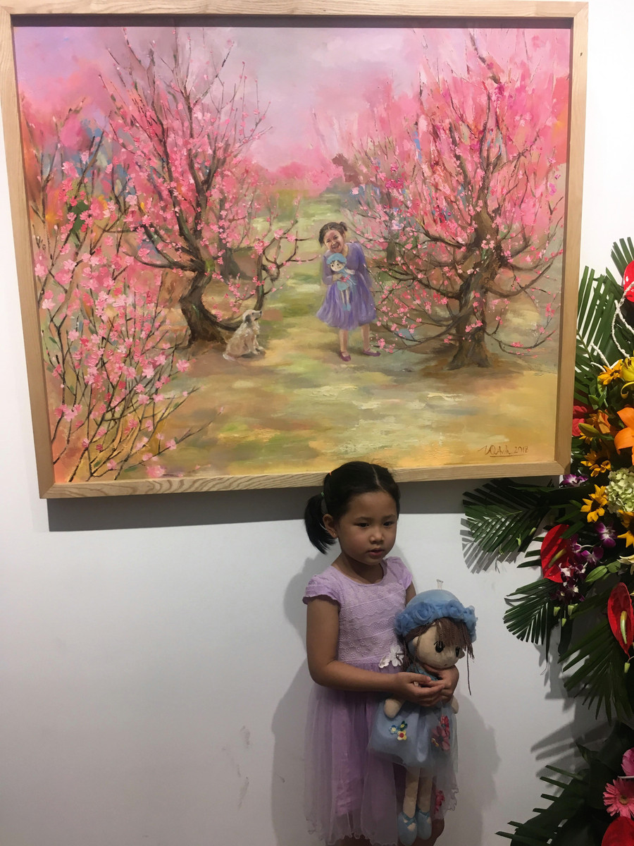 Người mẫu nhí bên tác phẩm của mẹ - họa sỹ Trịnh Quế Anh