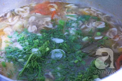 Cuối cùng rắc hành, thì là rồi tắt bếp, múc canh dưa chua nấu tép ra bát dùng nóng.