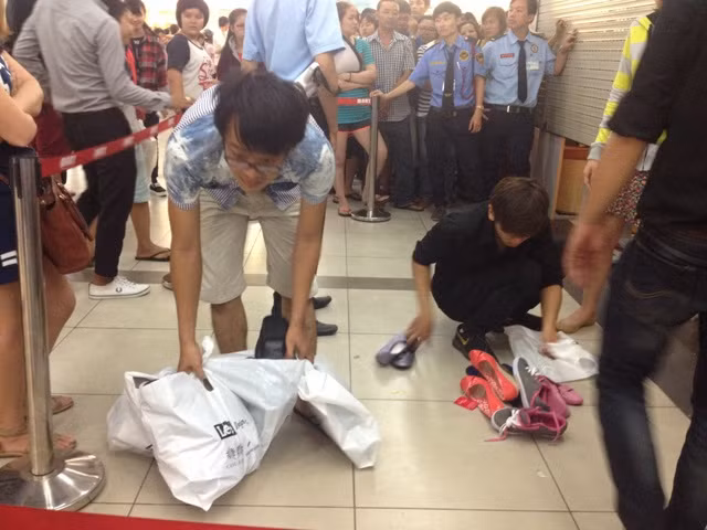 Xả hàng đồng giá, người dân "chui" cửa cuốn để mua giày