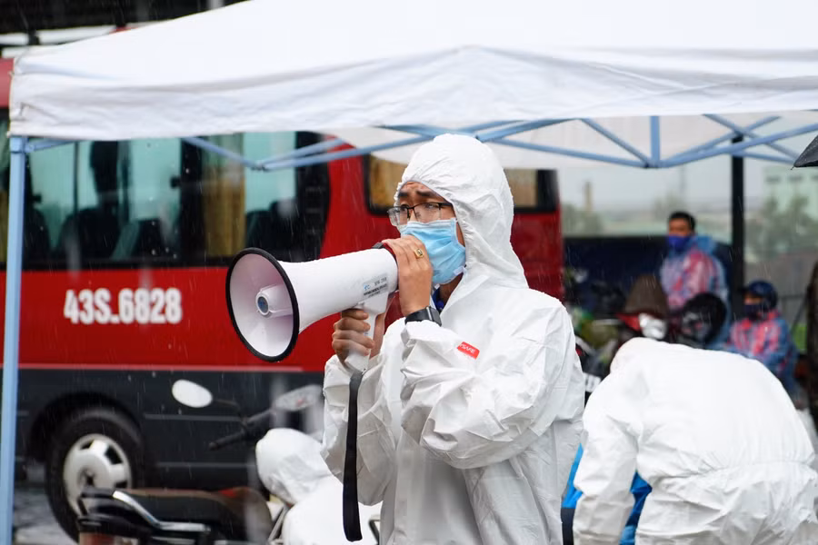 Thành viên Đội SOS SV ĐH Đông Á điều phối xe cộ, thông báo cho bà con các quy định của hầm Hải Vân và di chuyển theo đoàn.