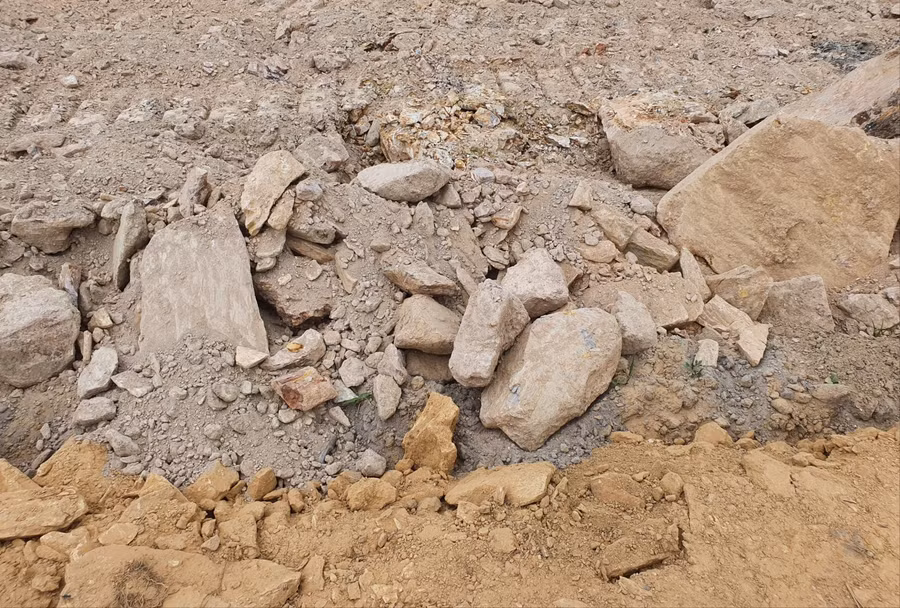 Nhiều đá tảng to lẫn trong đất san lấp khiến người dân hoài nghi về chất lượng công trình.