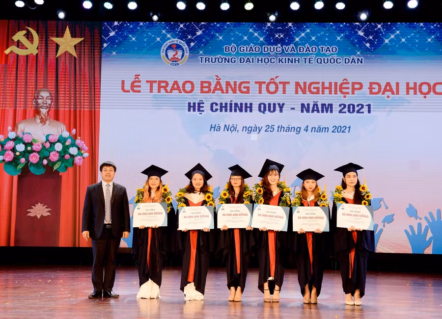 Đại diện lãnh đạo các đơn vị trao học bổng cao học cho các tân cử nhân.