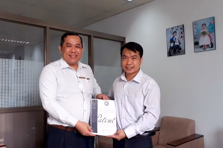 TS Lê Văn Út (bên trái) trao bằng sáng chế do USPTO cấp cho TS Đỗ Hoàng Thịnh.