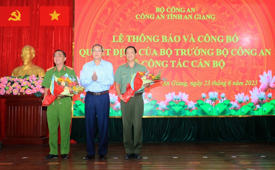 Ông Lê Văn Nưng - Phó Bí thư Thường trực Tỉnh ủy, Chủ tịch HĐND tỉnh An Giang tặng hoa cho đại tá Bùi Bé Năm và đại tá Nguyễn Nhật Trường. (Ảnh: Tiến Tầm)
