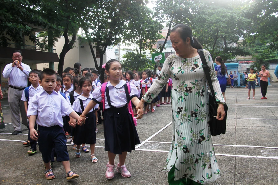 Các em học sinh lớp 1 được giáo viên dẫn vào lớp trong ngày tựu trường 